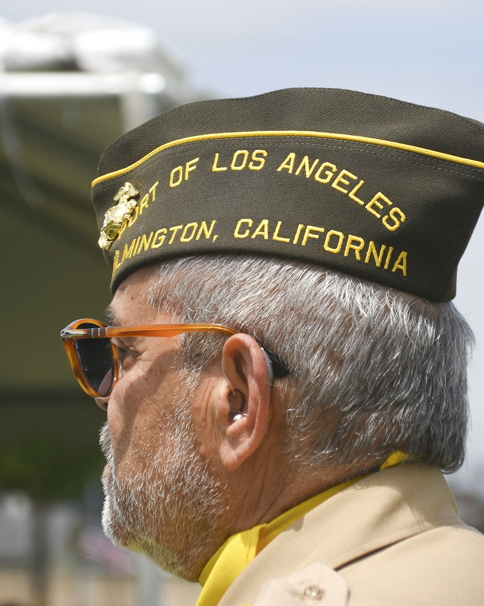 A person wearing sunglasses and a cap with the text "Port of Los Angeles, Wilmington, California."