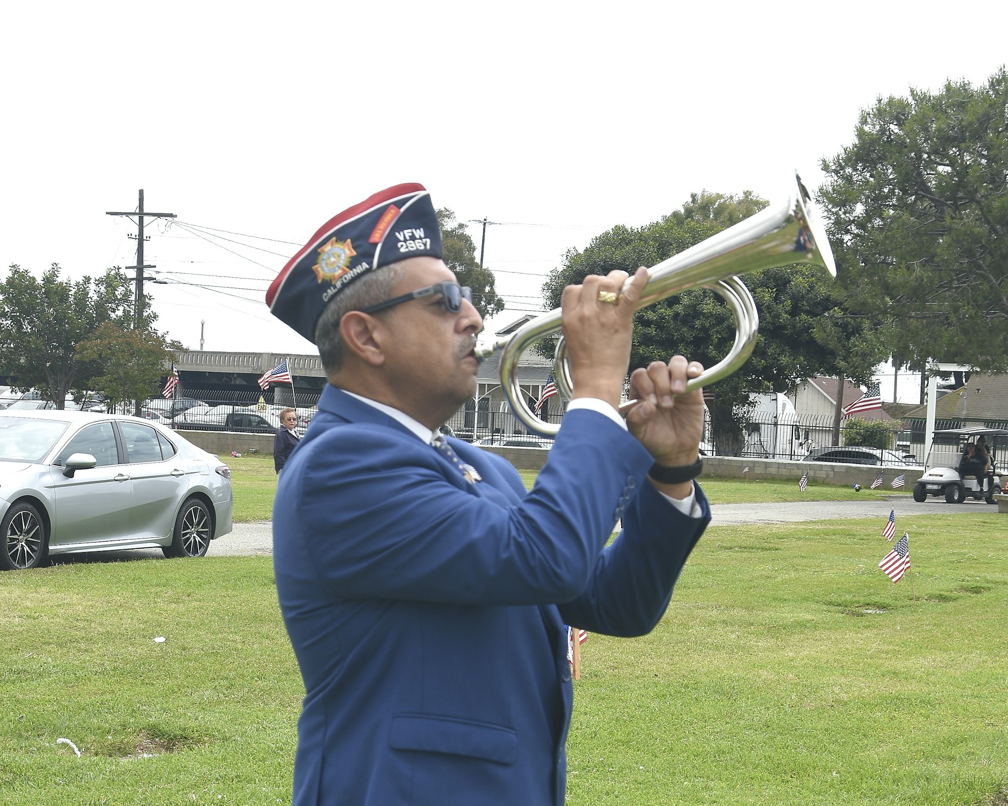 May contain: flag, adult, male, man, person, car, transportation, vehicle, clothing, hat, brass section, flugelhorn, musical instrument, accessories, glasses, alloy wheel, car wheel, machine, spoke, tire, wheel, and horn