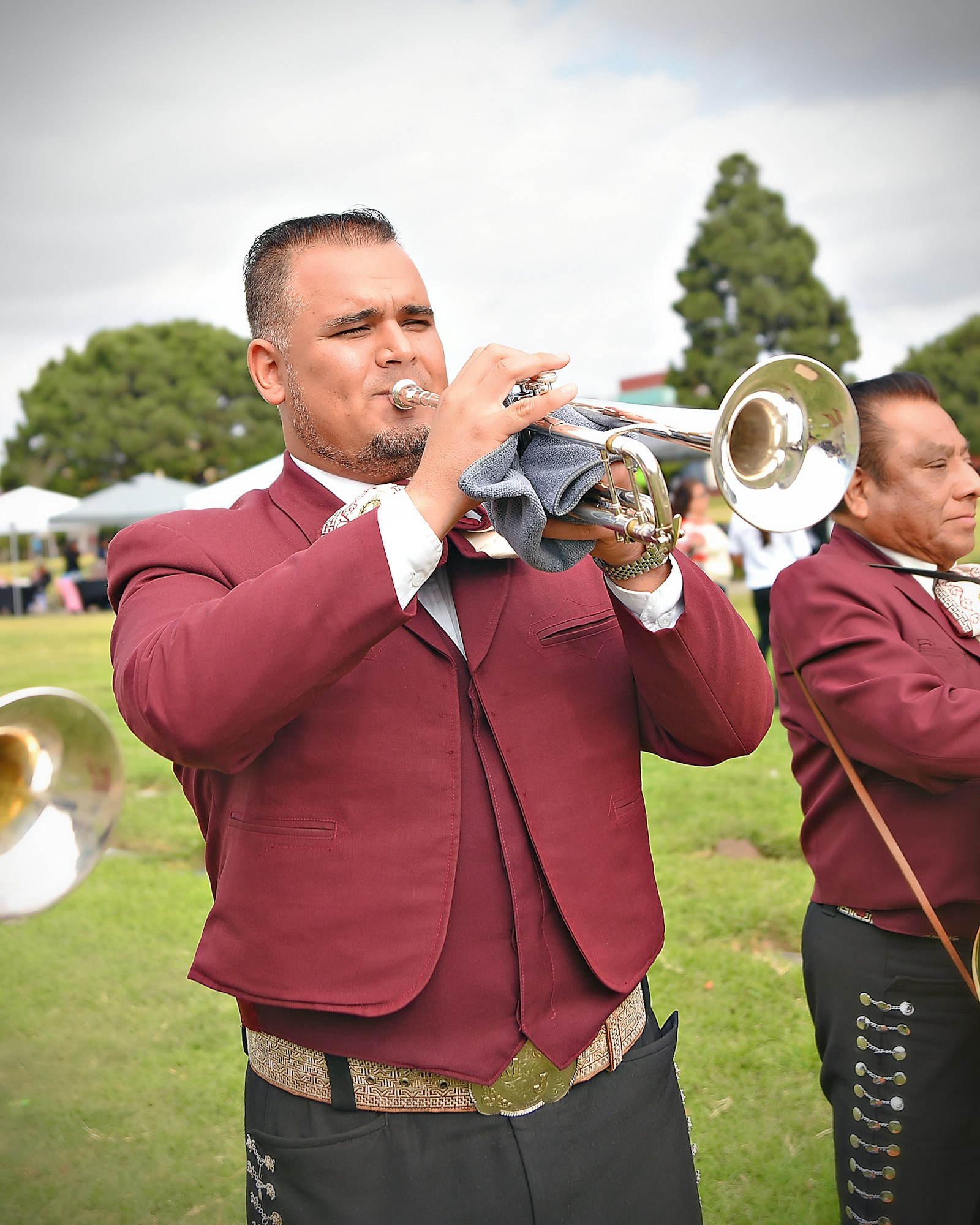 A man playing a trumpet, dressed in formal attire, with another musician in the background. #music #performance