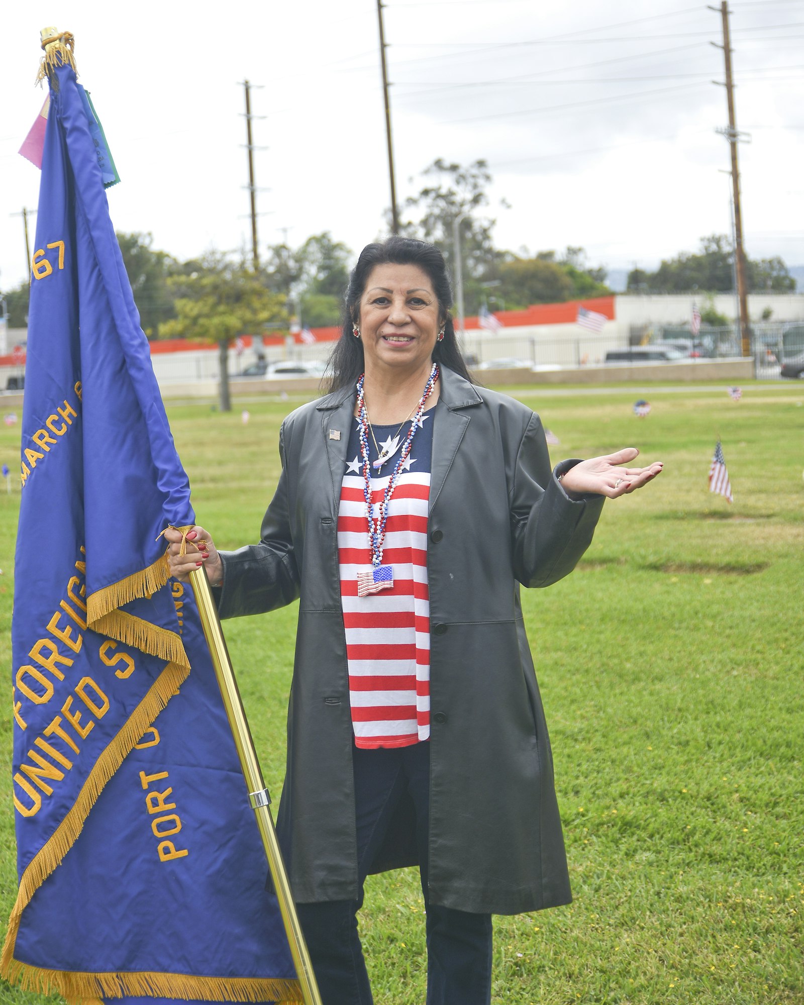 May contain: clothing, coat, people, person, long sleeve, sleeve, flag, accessories, jewelry, necklace, grass, and plant