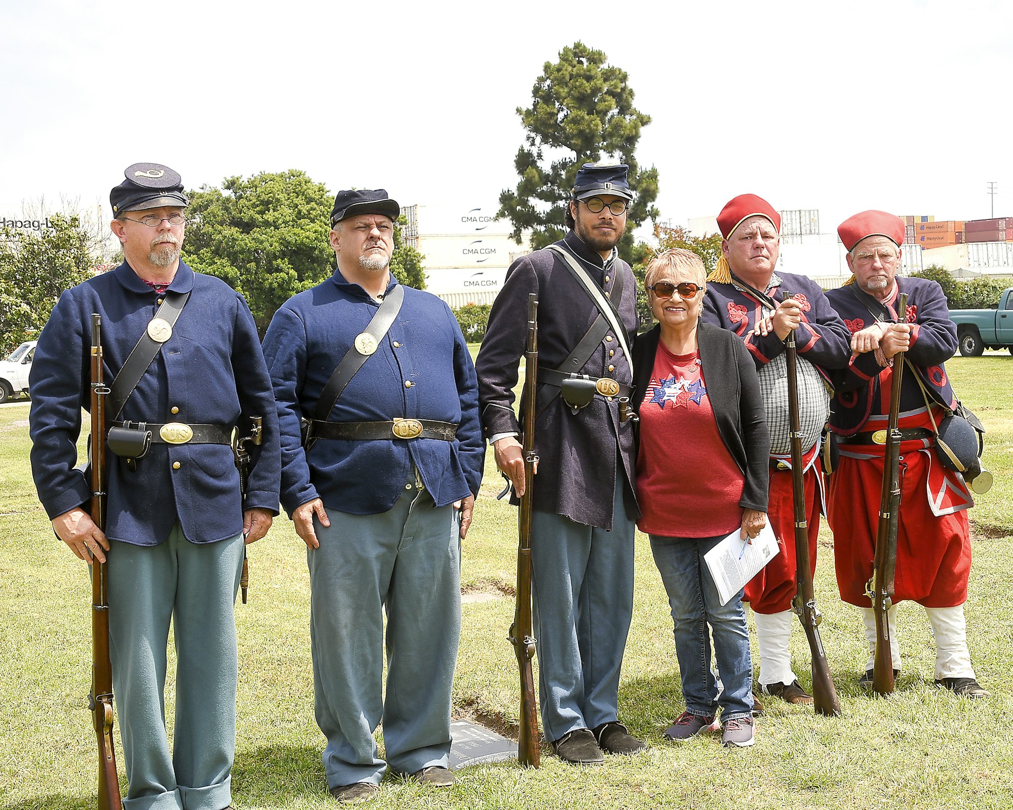 Group of individuals in historical military costumes with a civilian.