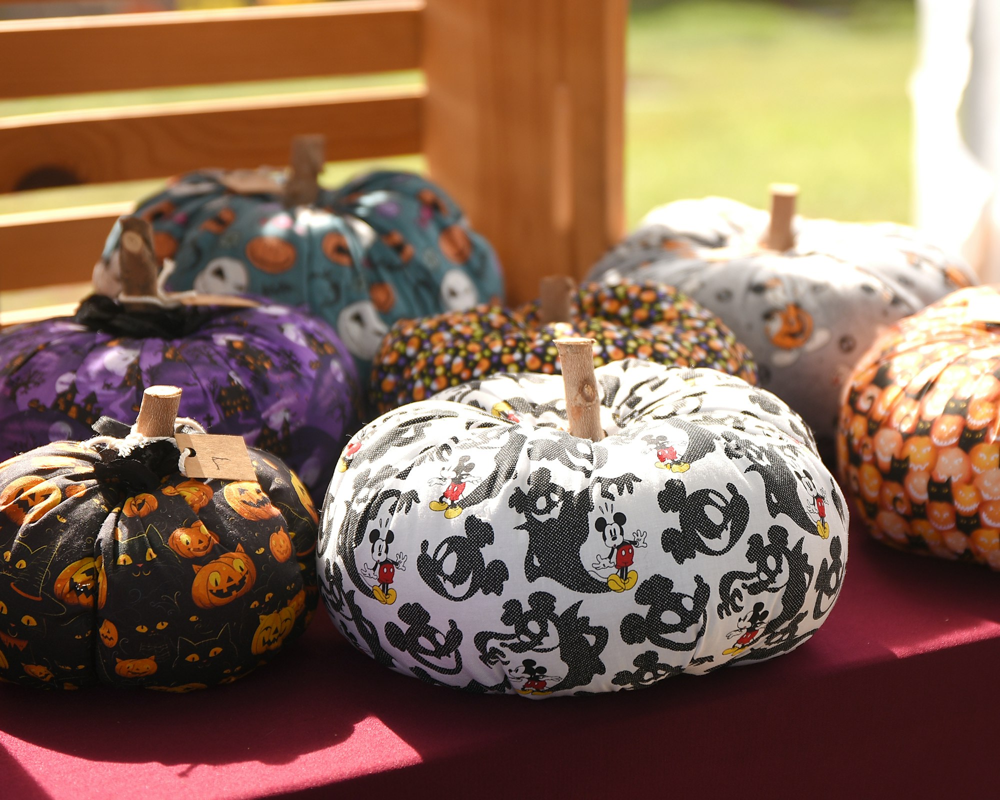 Fabric-covered pumpkins with Halloween-themed patterns on display.