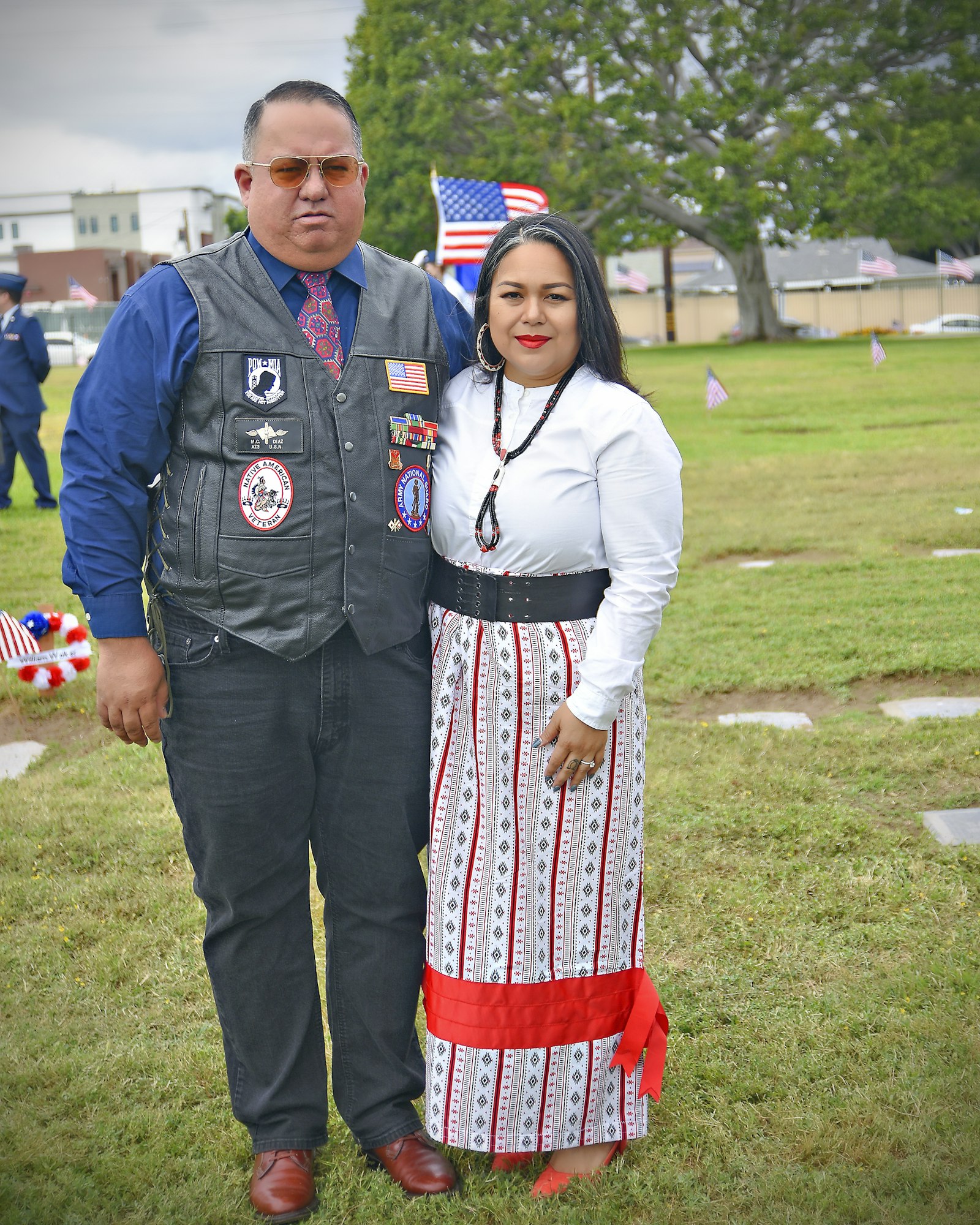 May contain: clothing, pants, person, adult, male, man, accessories, formal wear, tie, car, transportation, vehicle, footwear, shoe, flag, hat, grass, and plant