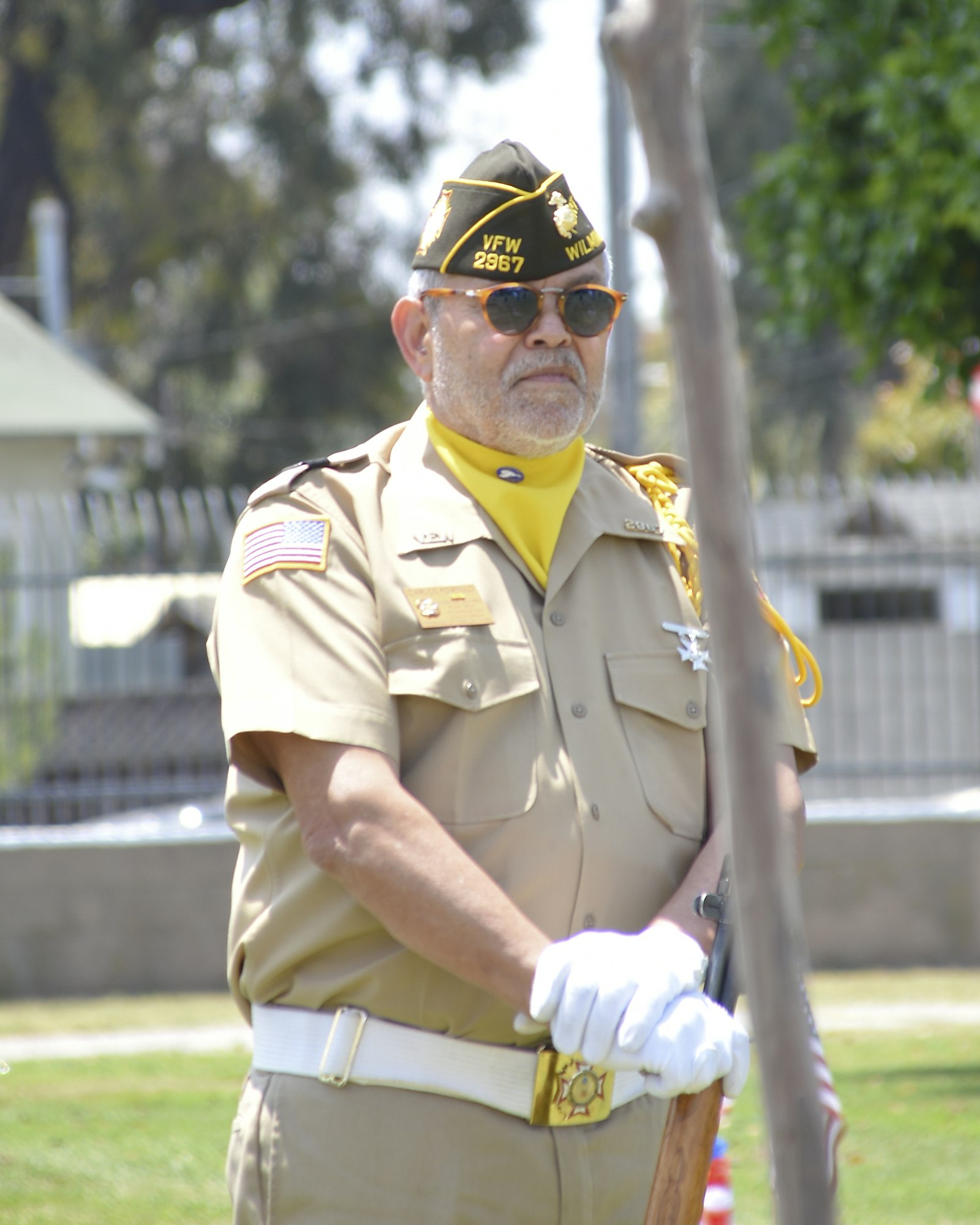 A person in uniform with a VFW cap, sunglasses, and white gloves, possibly at a ceremonial event.