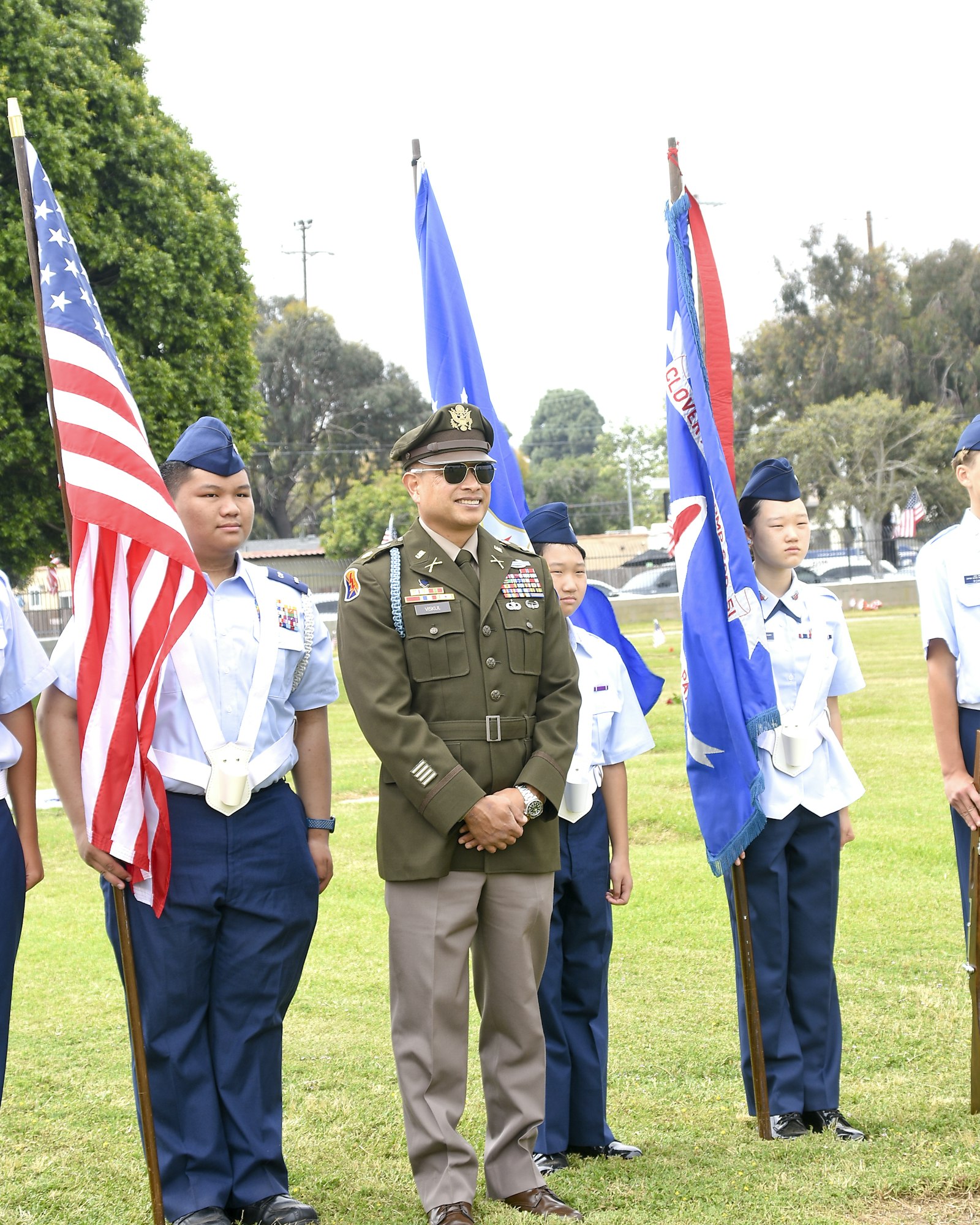 Uniformed individuals with flags in what appears to be a formal gathering or ceremony.