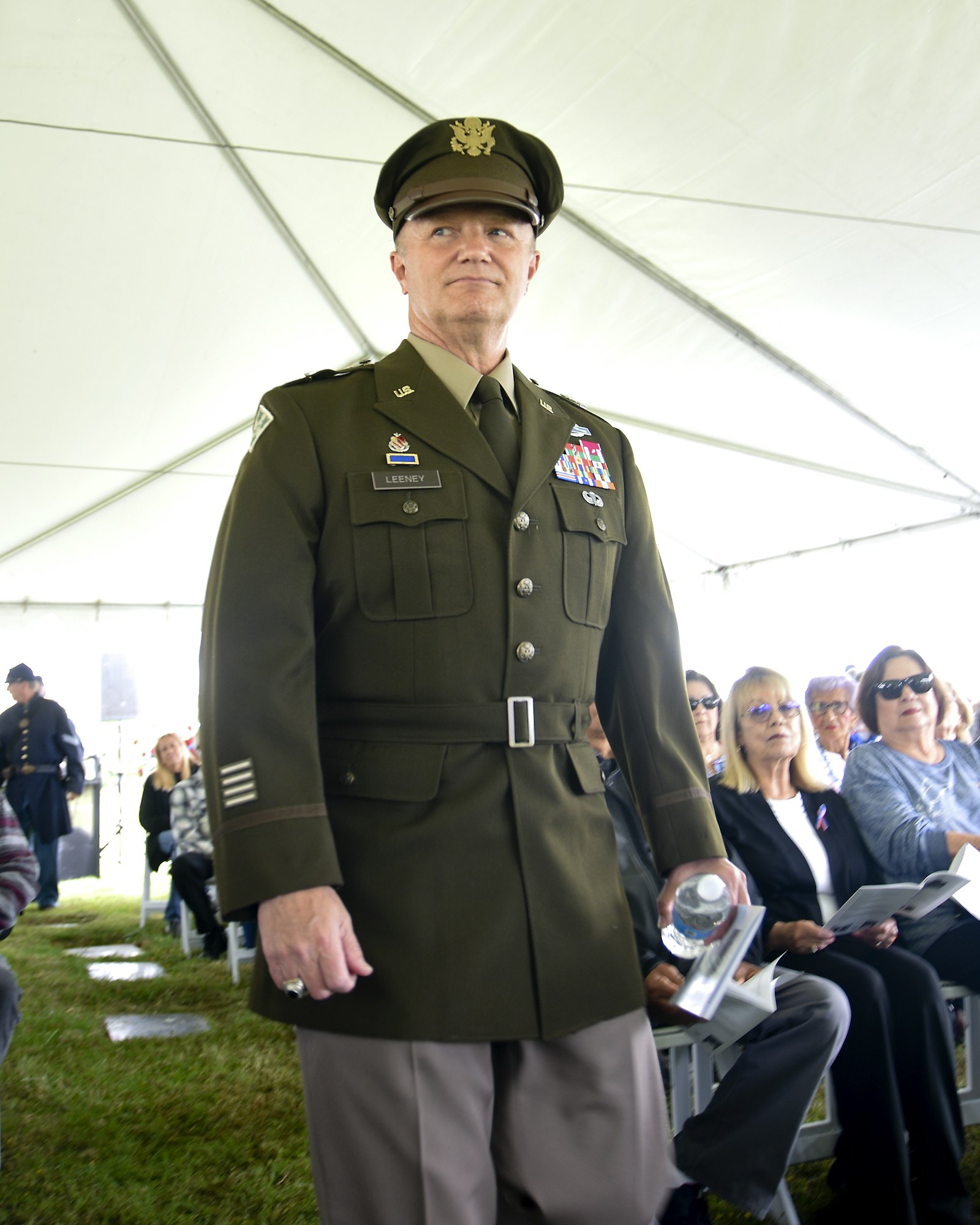 May contain: captain, officer, person, accessories, formal wear, tie, adult, female, woman, male, man, clothing, hat, glasses, jewelry, ring, coat, footwear, shoe, and military