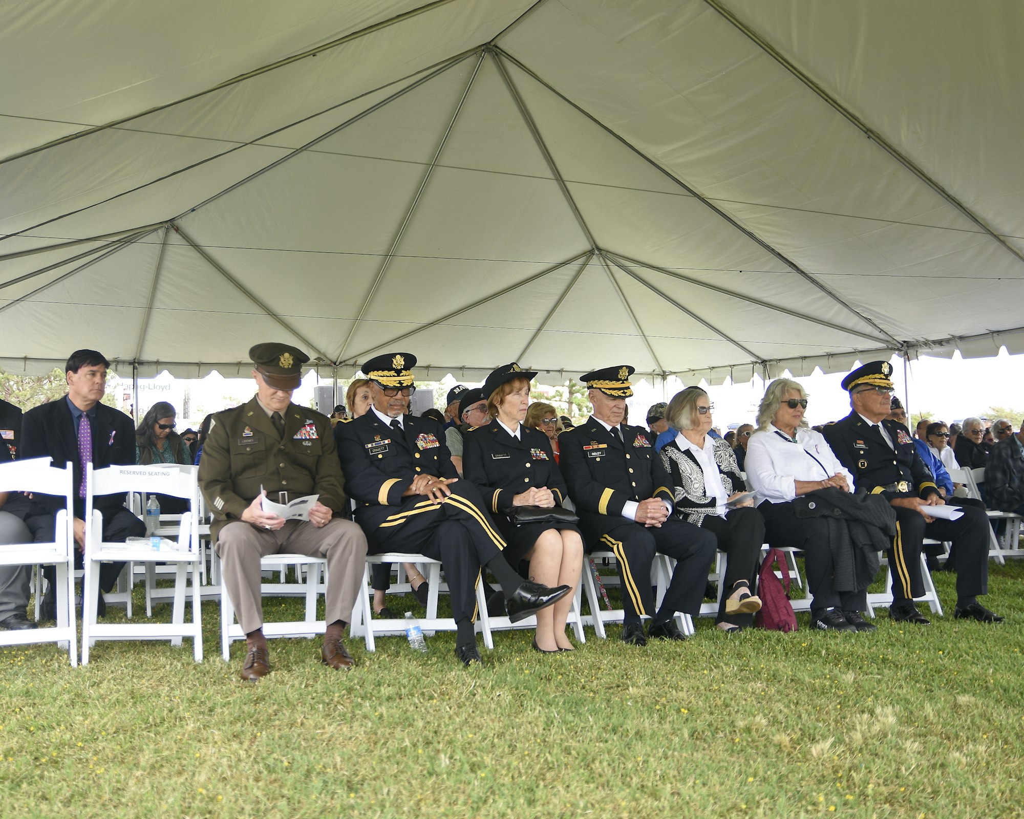 May contain: clothing, footwear, shoe, adult, female, person, woman, hat, male, man, captain, officer, accessories, glasses, people, formal wear, tie, grass, plant, bag, handbag, military, and military uniform