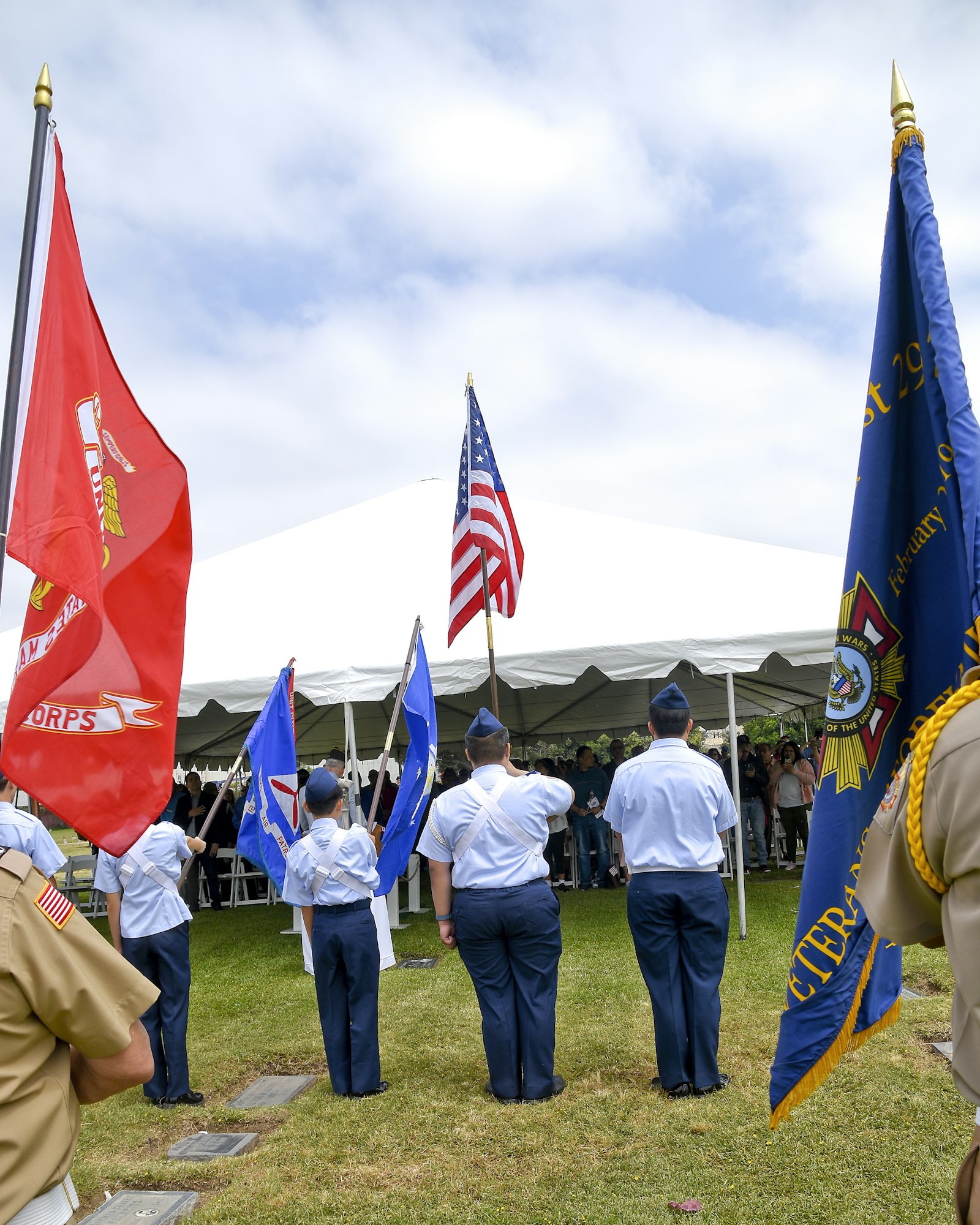 Military personnel holding flags at a formal ceremony.