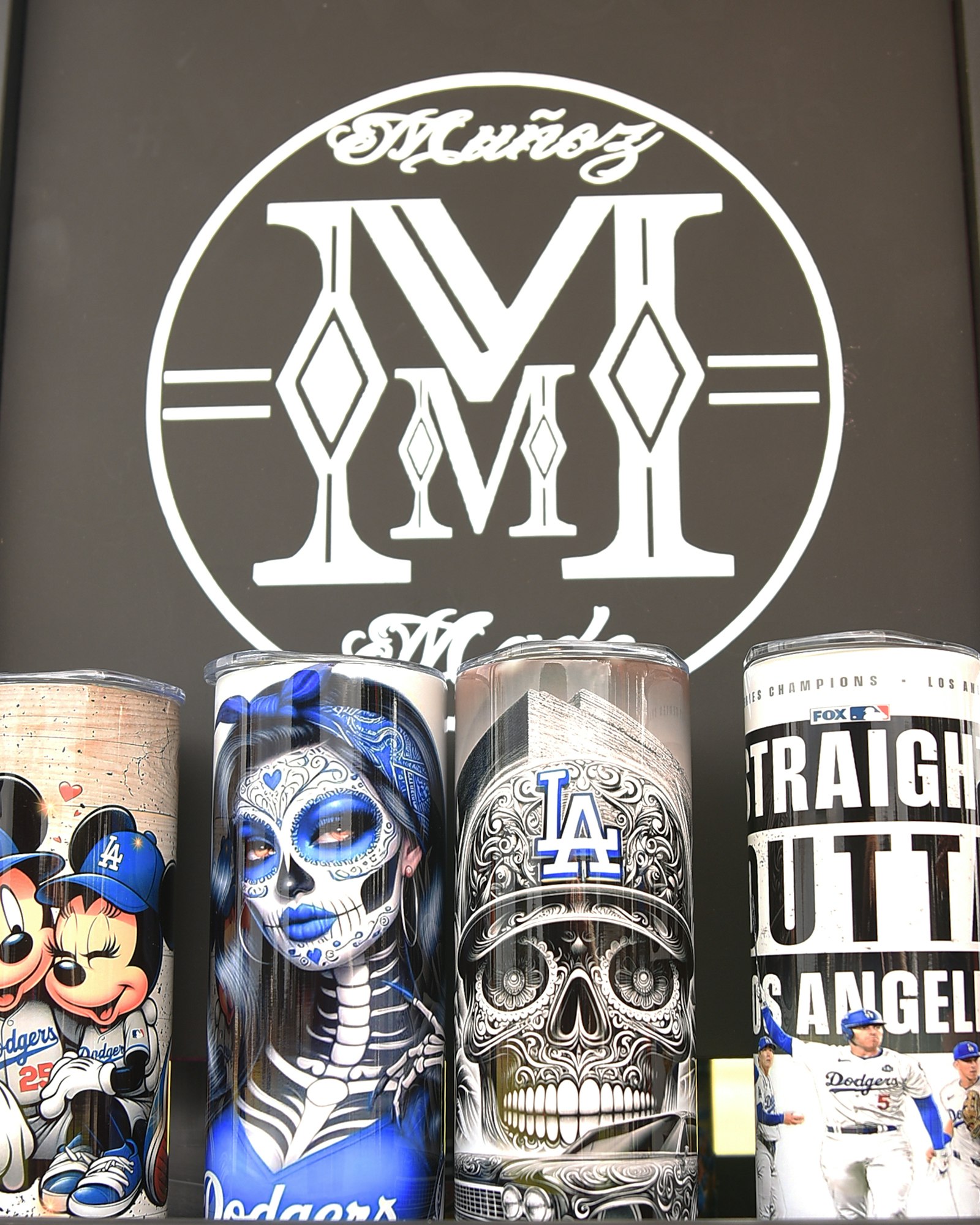 Cans with detailed artwork featuring LA Dodgers, skulls in Day of the Dead style, and team graphics.