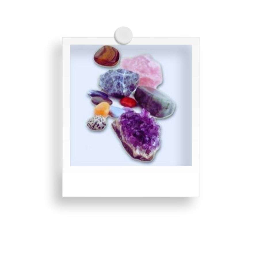 A collection of colorful gemstones and crystals, including amethyst and rose quartz, displayed on a white background.