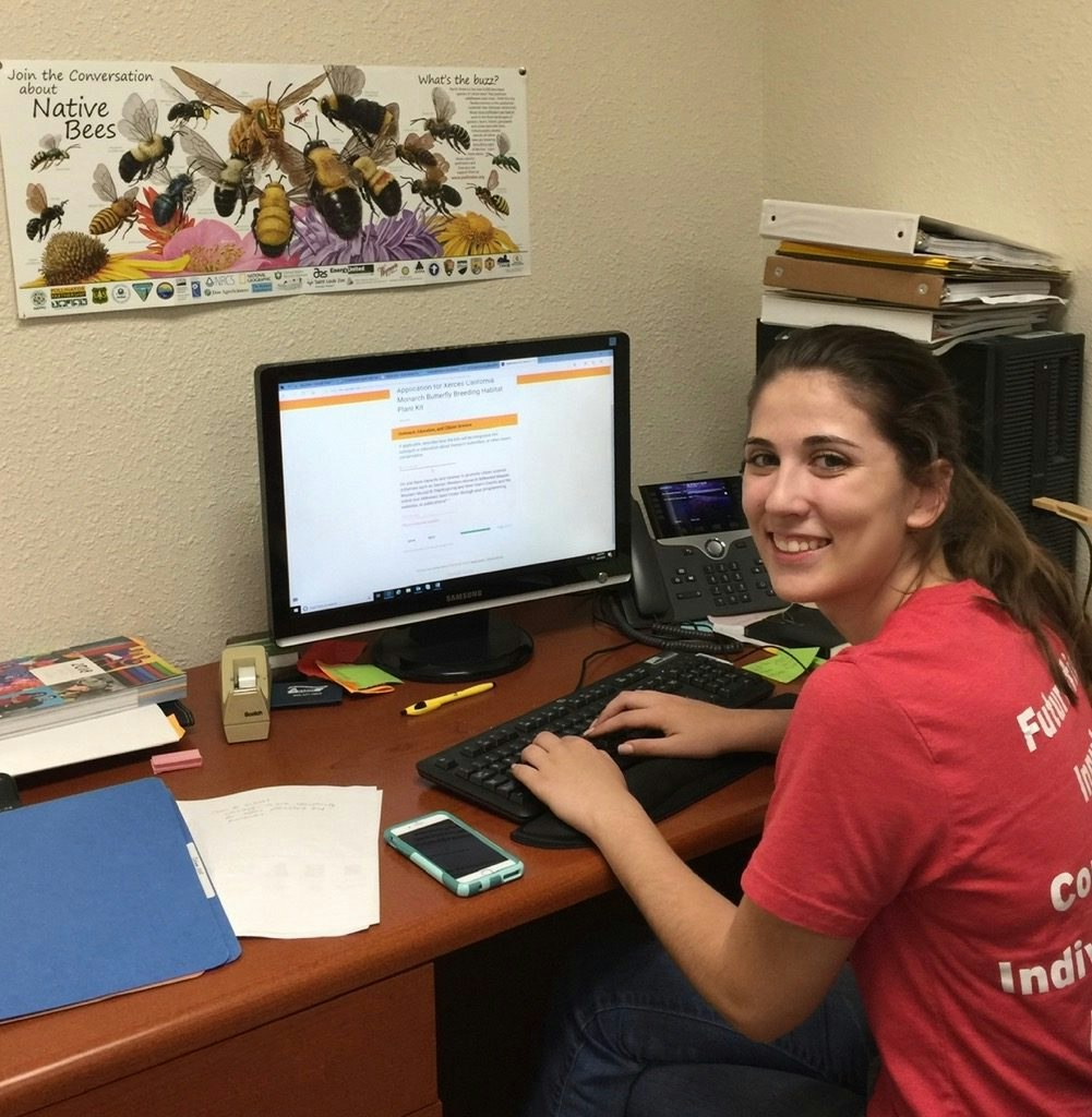 May contain: furniture, table, desk, person, human, electronics, monitor, display, screen, computer, keyboard, hardware, computer hardware, and computer keyboard