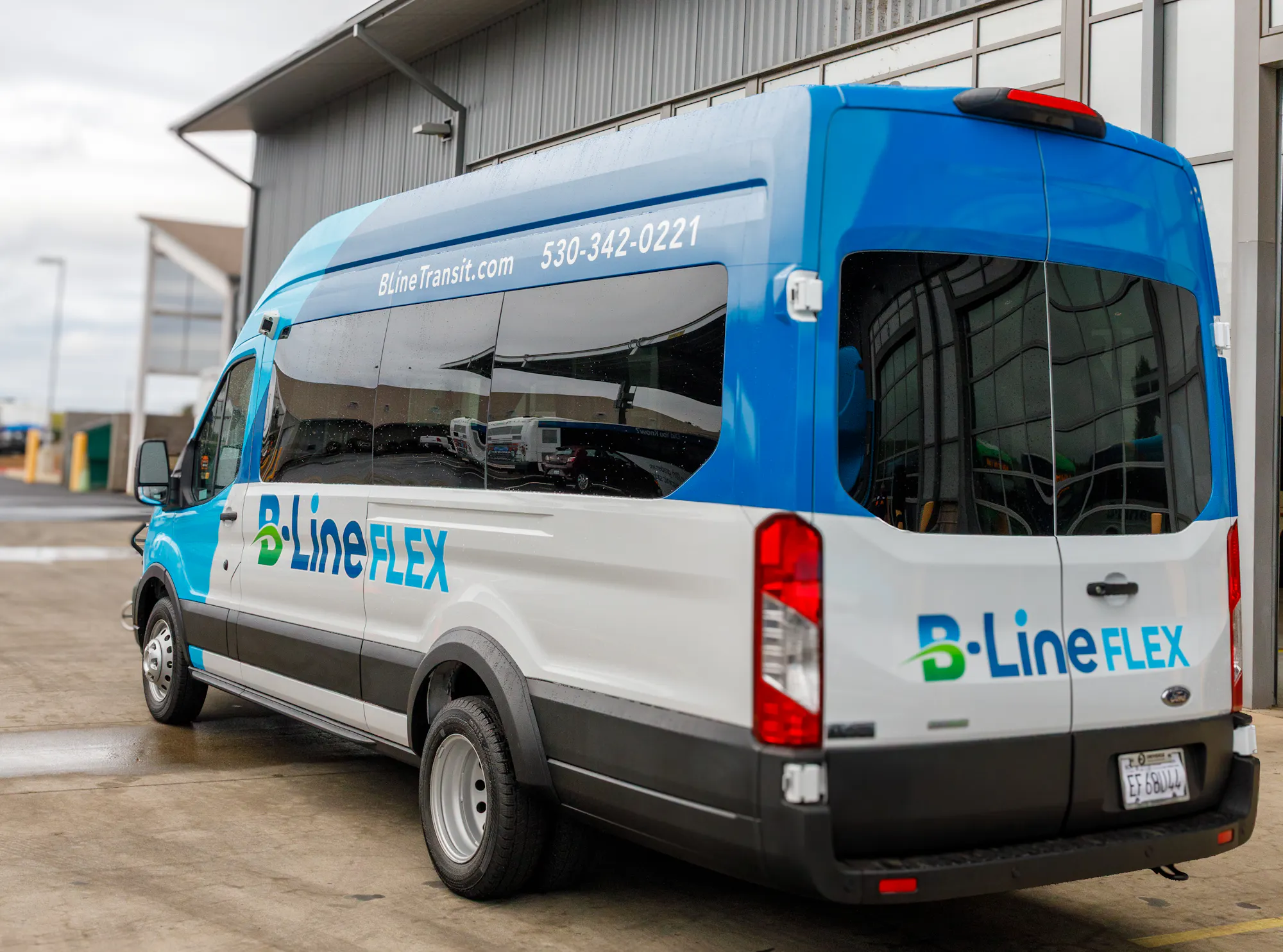 The image shows a B-Line FLEX transit van parked outside a building, with branding and contact information visible.