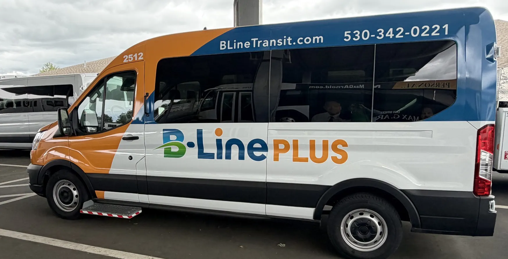 The image shows a B-Line Plus transit van parked under a shelter, with contact details and a modern design.