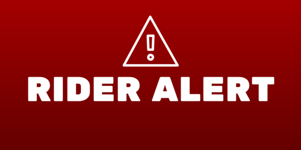 Red sign with "RIDER ALERT" in white text and an exclamation mark in a triangle above it.