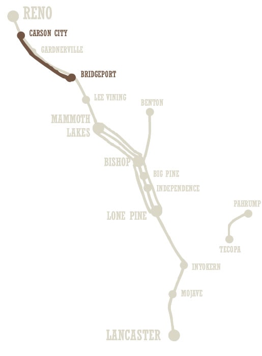 A stylized map showing a route with cities like Reno, Mammoth Lakes, and Lancaster labeled.