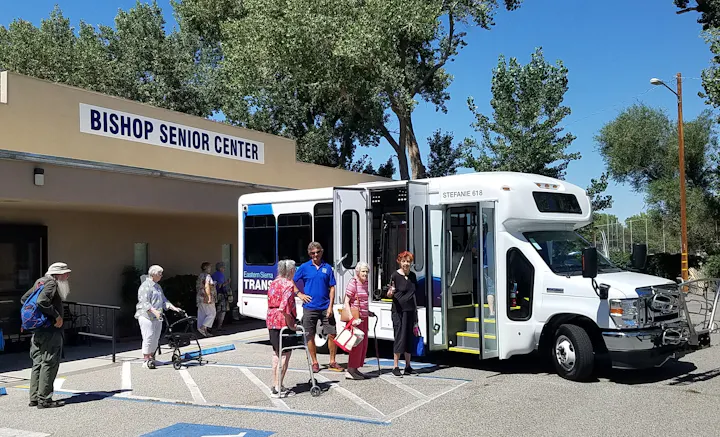 Seniors disembarking a bus at a senior center.