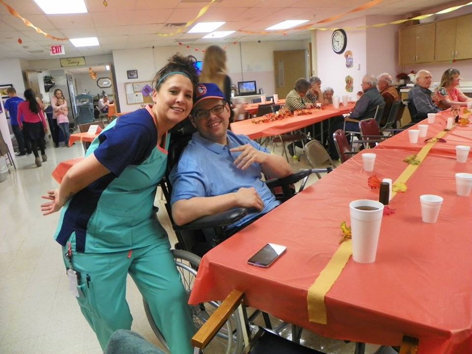 Two people smiling at a social gathering with decorated tables.