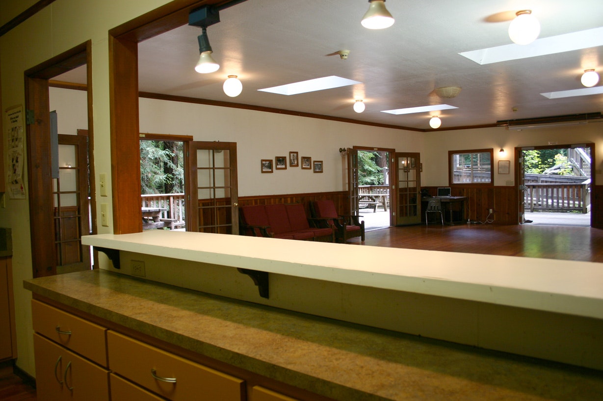 Interior of a room with a counter, couches, and French doors leading to a deck.