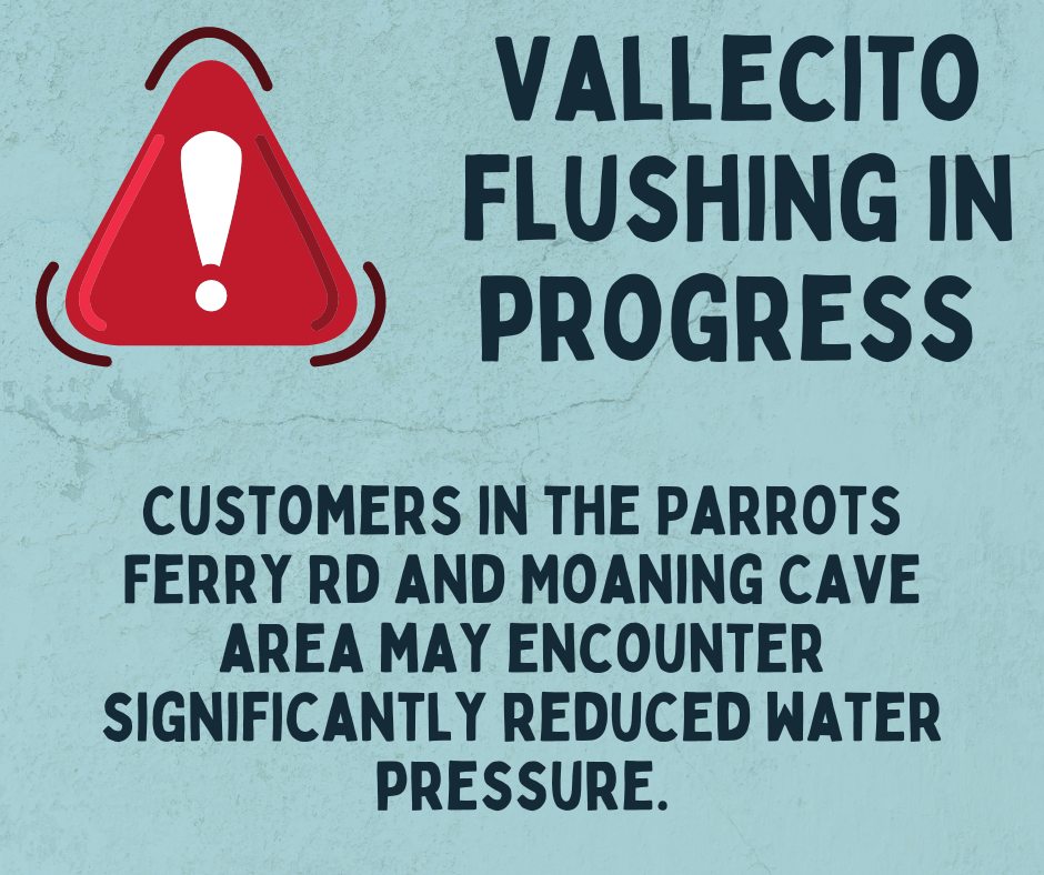 A warning sign about water flushing causing reduced pressure for nearby customers.