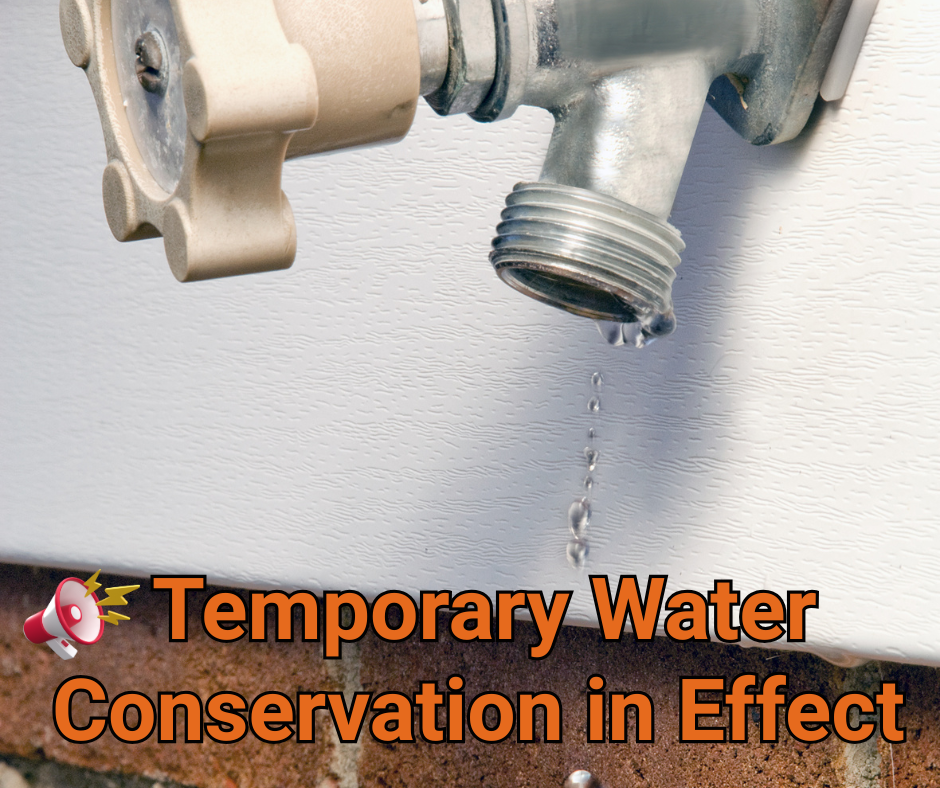 Leaking outdoor faucet with text: "Temporary Water Conservation in Effect."