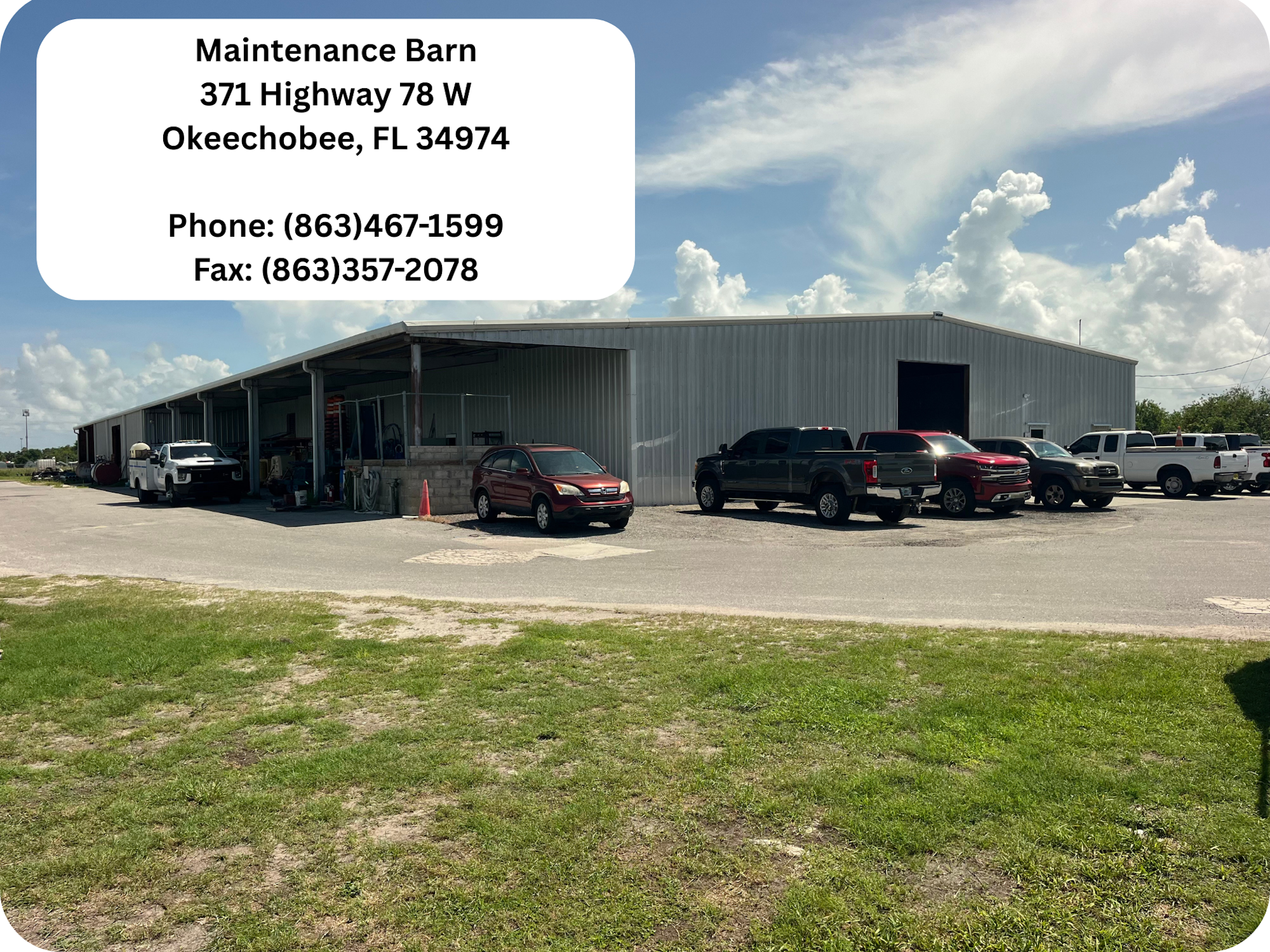 A maintenance barn with several parked vehicles and contact details for Okeechobee, FL.