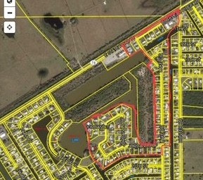 The image shows a map with residential areas outlined in yellow, a waterway, and distinct boundaries marked in red.