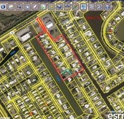 The image shows a map with marked properties, streets, and a canal in a residential area. Yellow lines indicate property boundaries.