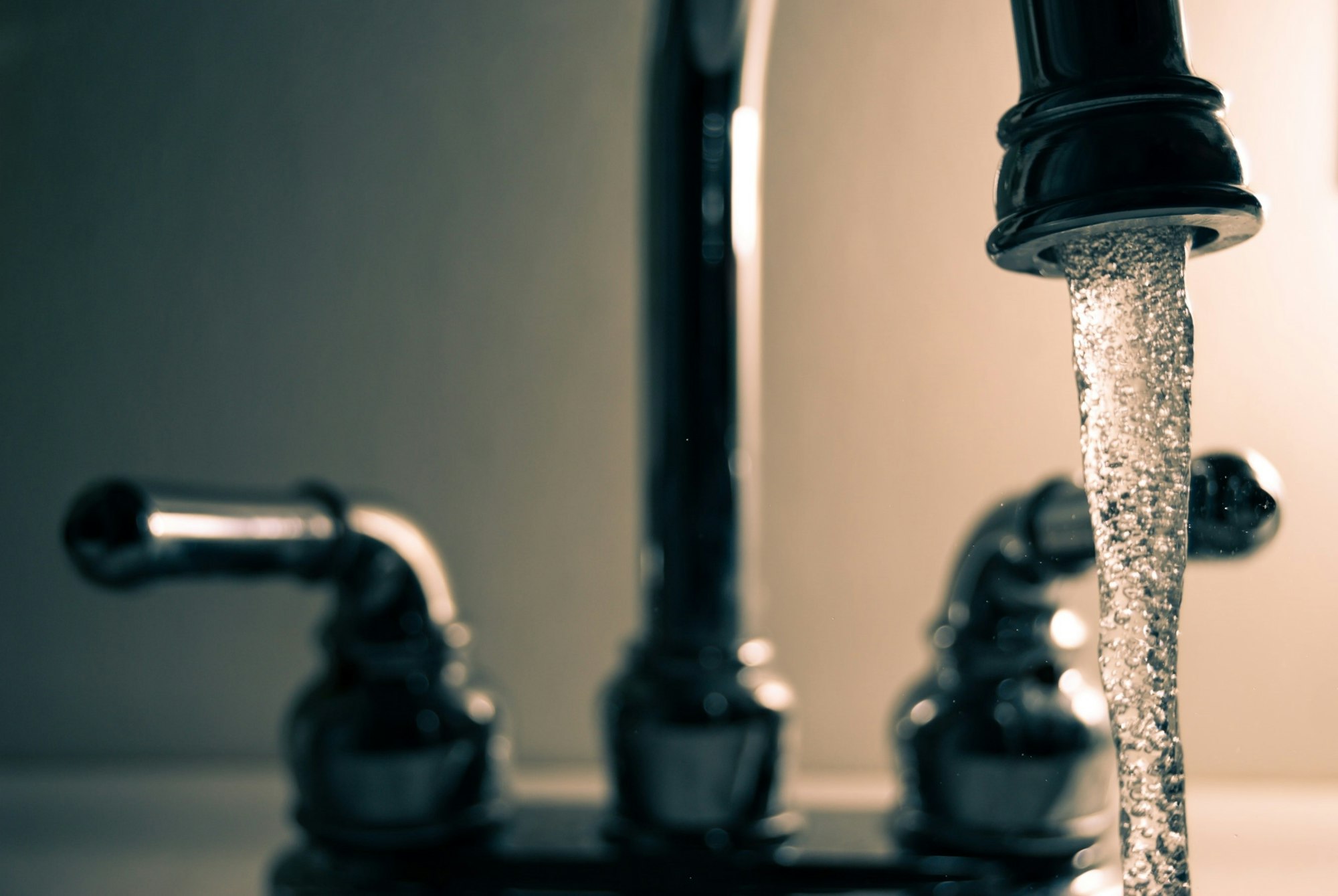 Close-up of a water faucet with water flowing.